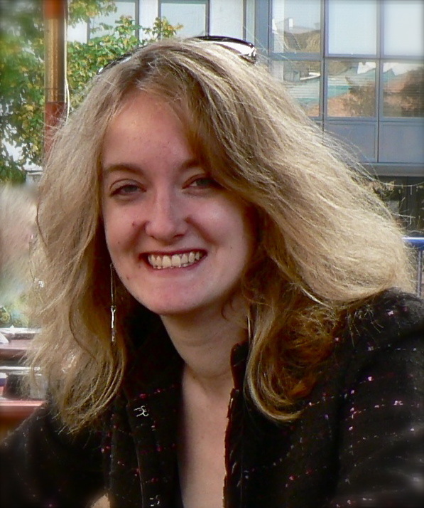 Portrait of Emily List, a smiling young woman with a light skin tone and shoulder-length blond hair.