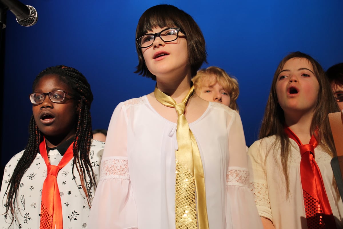  A diverse group of children, eaching wearing different colored ties, sing in the Whole Children Joyful Chorus.